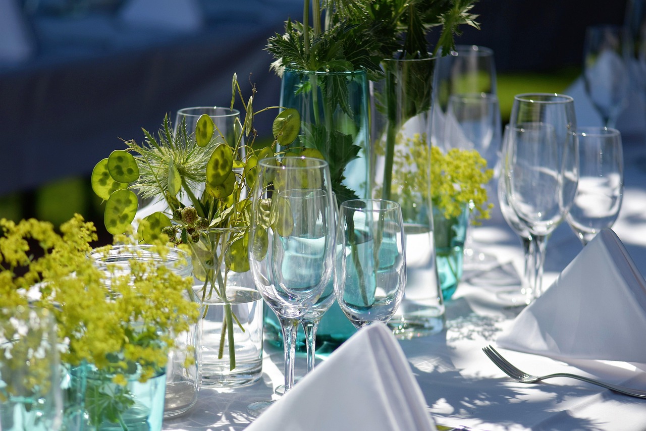 Table dressée en extérieur au soleil avec verres et fleurs