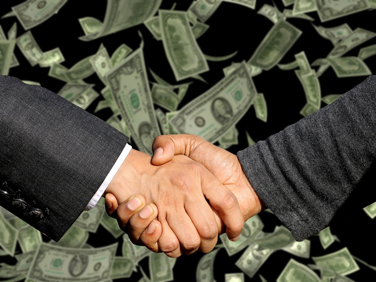 Poignée de main entre deux professionnels sur fond de billets